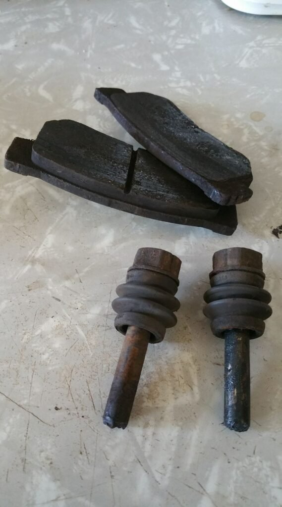 Failing to lubricate the caliper slide pins when changing brakes can lead to early brake failure. Note the rust on one of the caliper pins and how one pad is gone while the other looks almost new.